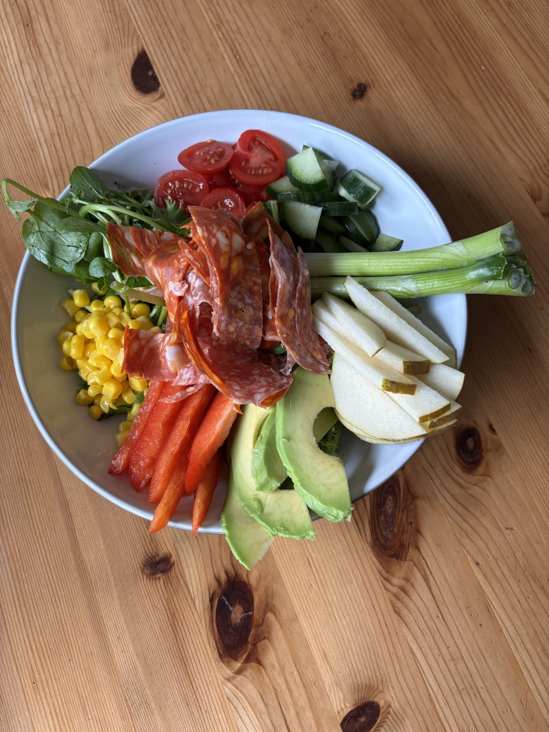 Bowl of Salad, pear, avocado, sping onion, sweet corn, lettuce, watercress, tomotoes, cucumber, pepper, Salami sausage